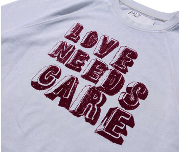 LOVE NEEDS CARE CREWNECK