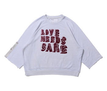 LOVE NEEDS CARE CREWNECK