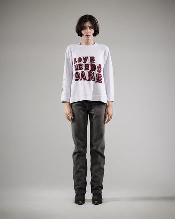 LOVE NEEDS CARE CREWNECK